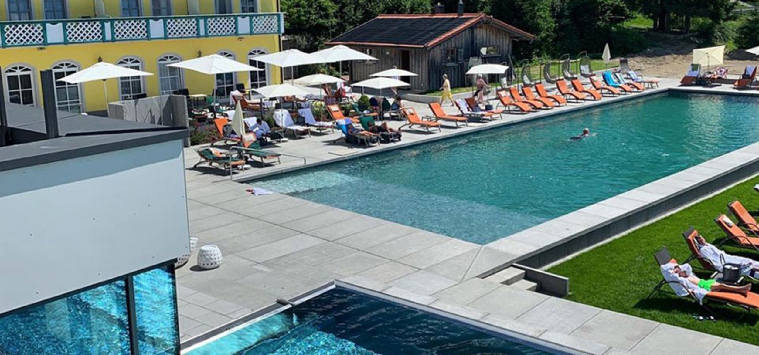 Naturpool mit Balena-System mit Liegen und Gästen im Sport- und Wellness­hotel „Angerhof” in St. Englmar